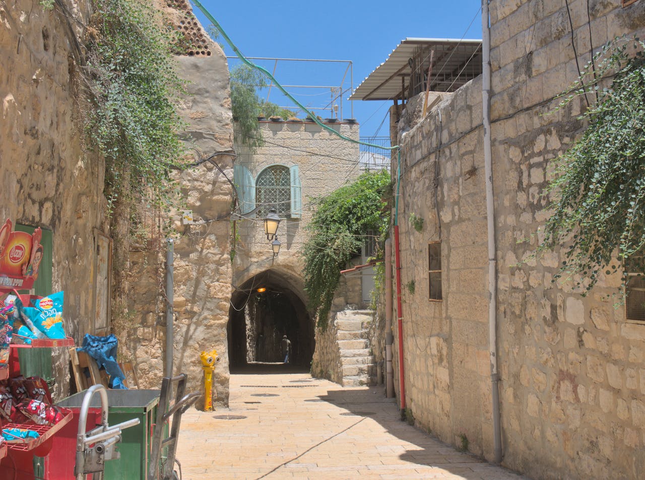 Charming narrow alleyway with cobbled streets in Jerusalem's historic old town, showcasing ancient architecture.