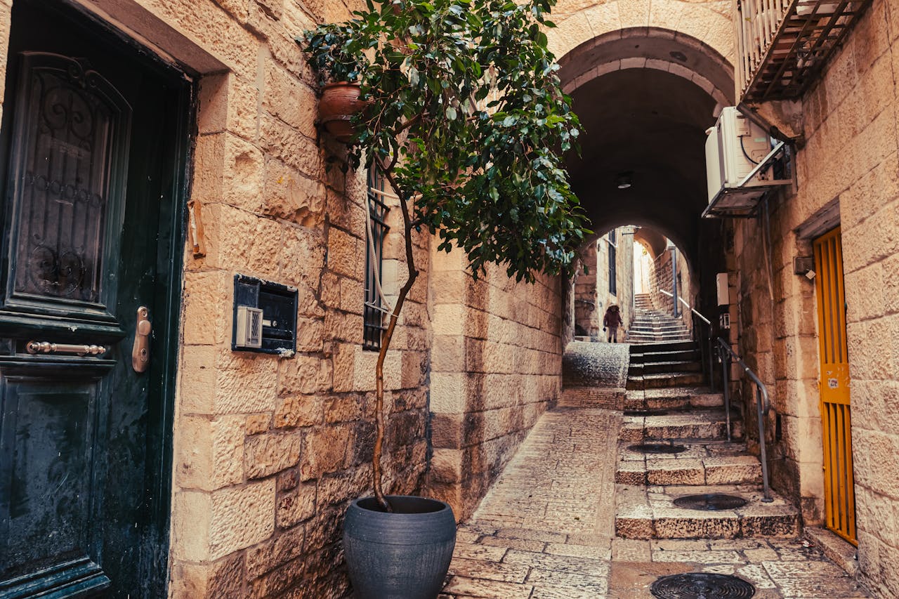 Explore the historic charm of a Jerusalem alleyway with stone walls and archways.